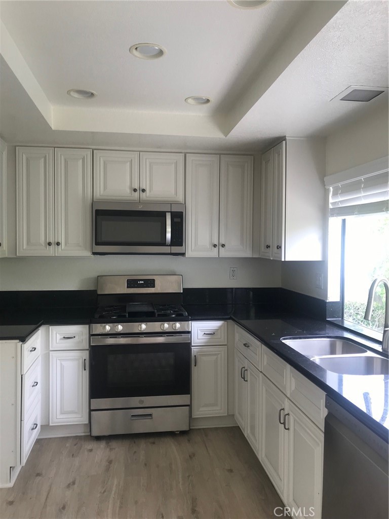 21 Silkberry Irvine, CA 92614 - Photo 9 of 18 a kitchen with stainless steel appliances granite countertop a sink a stove a microwave and cabinets