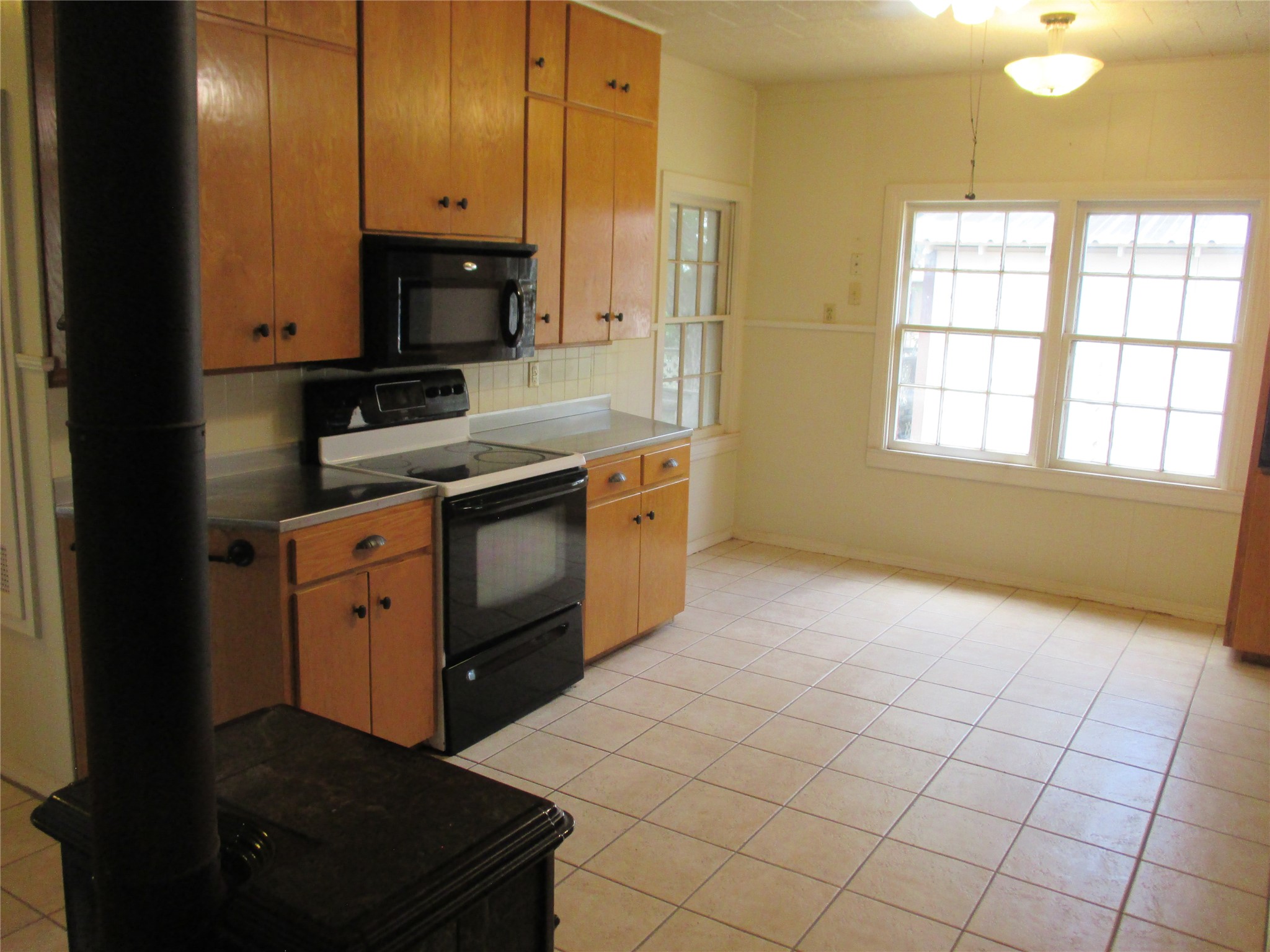 12610 Pecan School Road Bartlett, TX 76511 - Photo 8 of 21 A compact kitchen with functional appliances and bright windows provides a practical living space.