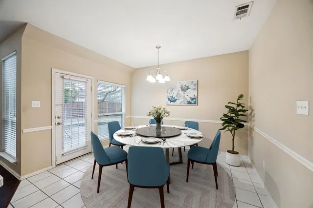 a dining room with furniture potted plants and wooden floor