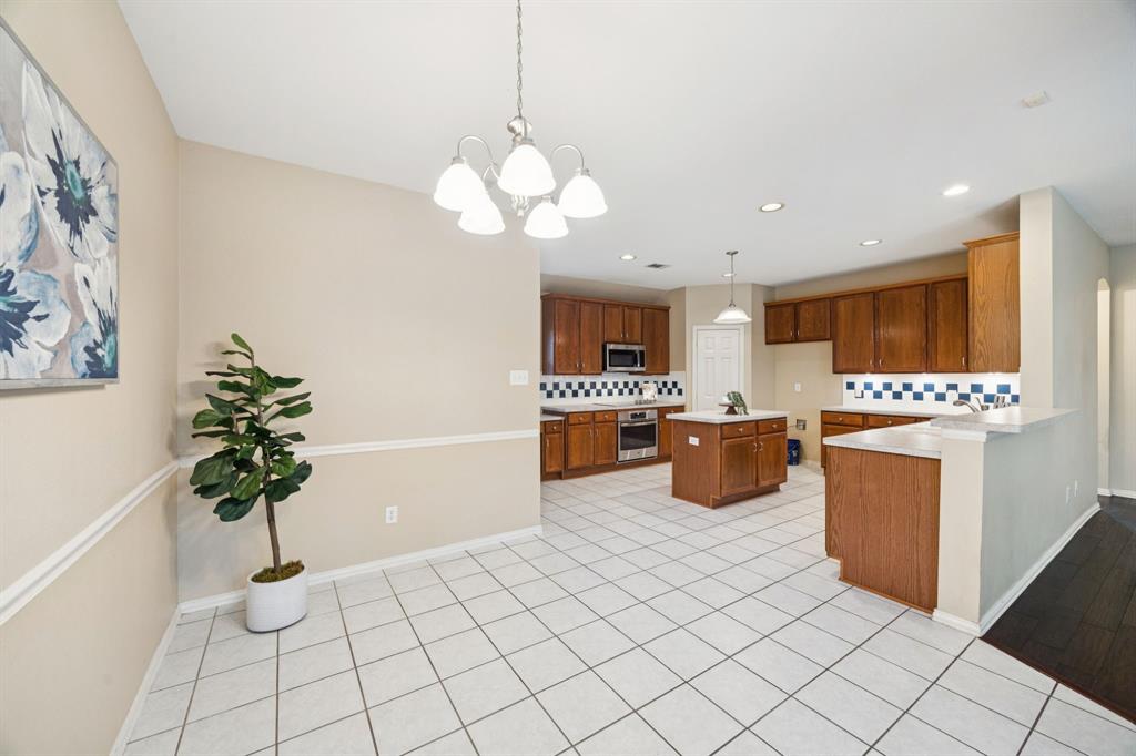 1516 High Country Lane Allen, TX 75002 - Photo 15 of 33 a kitchen with stainless steel appliances a counter space a sink a stove top oven a counter space and cabinets