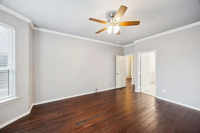 an empty room with wooden floor and window