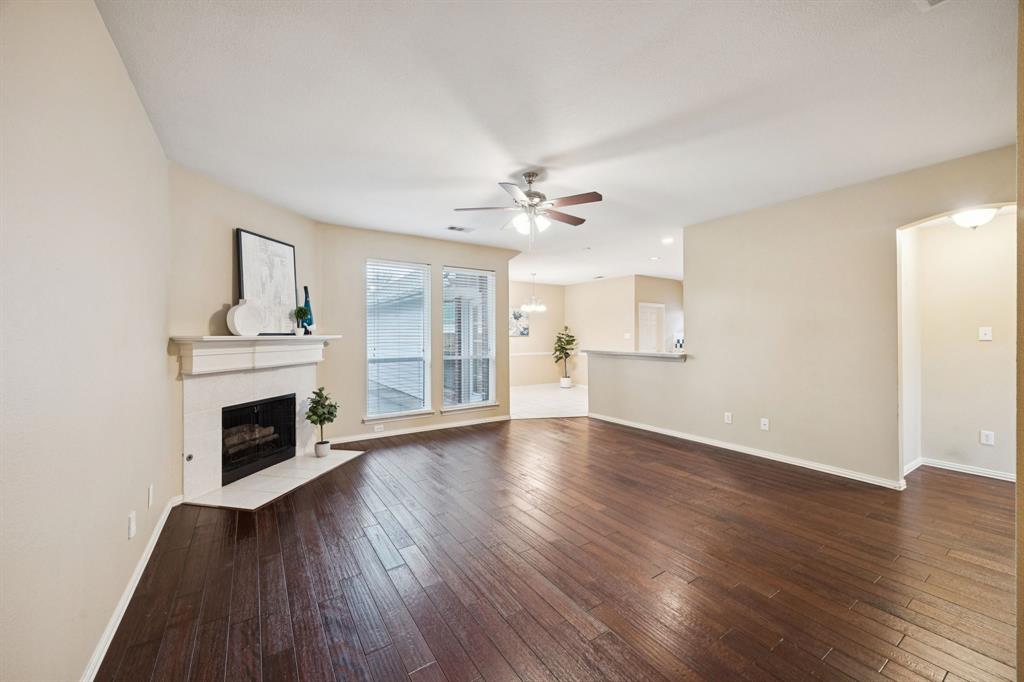 1516 High Country Lane Allen, TX 75002 - Photo 6 of 33 an empty room with wooden floor fireplace and windows