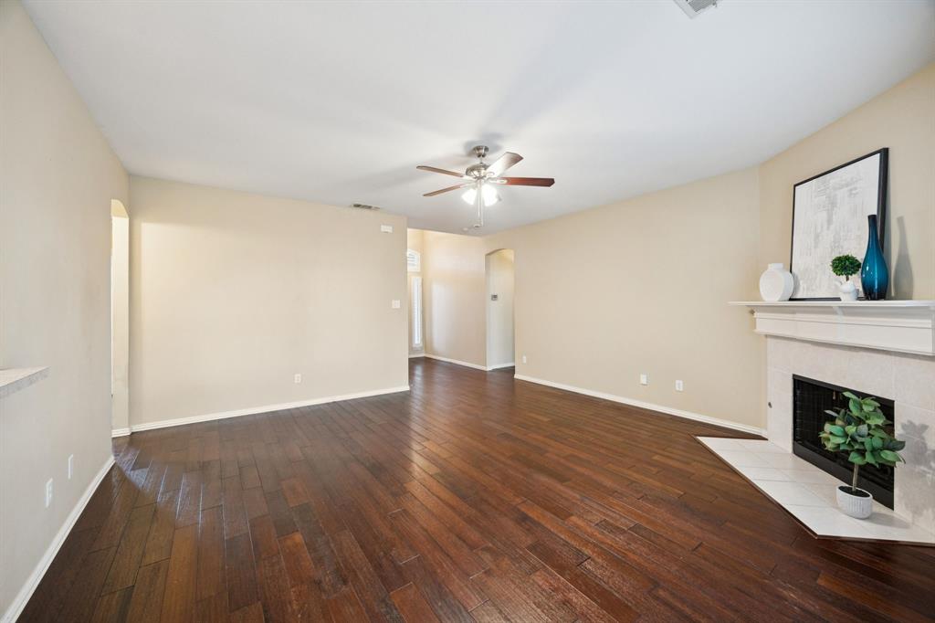 1516 High Country Lane Allen, TX 75002 - Photo 7 of 33 a view of an empty room with wooden floor and a fireplace