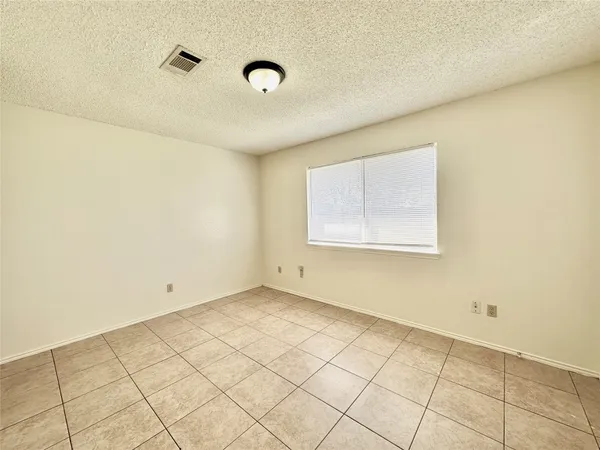 an empty room with white walls and tiles