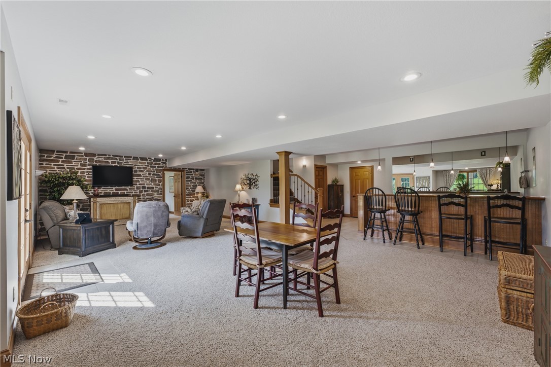 3955 Spring Brook Way Wooster, OH 44691 - Photo 28 of 50 Spacious lower-level living area with recessed lighting, a stone accent wall, a built-in bar, and a wooden staircase