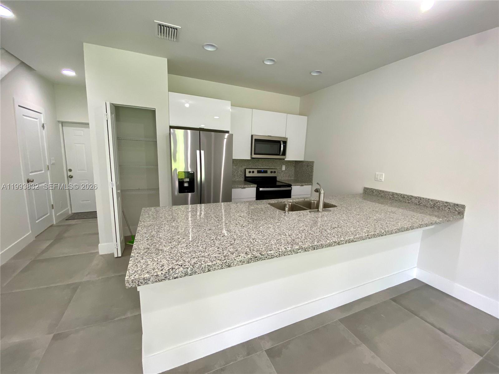 5860 Lincoln Street, Unit 5860 Hollywood, FL 33021 - Photo 4 of 21 a kitchen with sink refrigerator and microwave