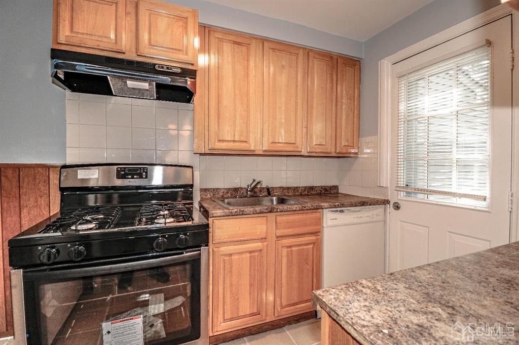 9 MacArthur Drive Edison, NJ 08837 - Photo 4 of 12 a kitchen with granite countertop wooden cabinets and a stove top oven