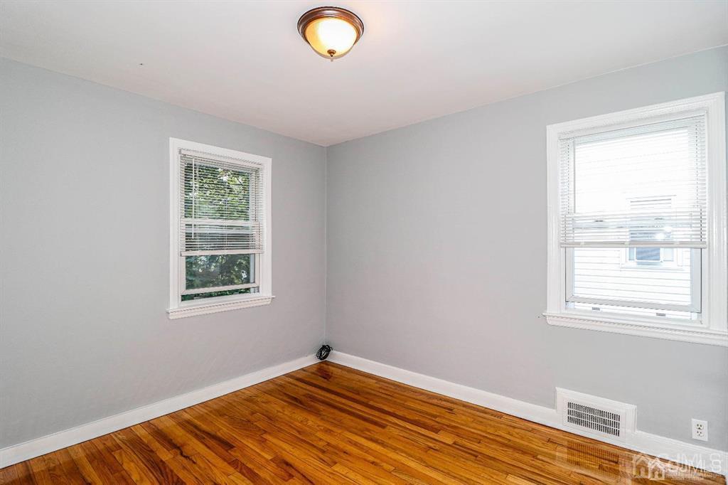 9 MacArthur Drive Edison, NJ 08837 - Photo 7 of 12 a view of an empty room with wooden floor and a window