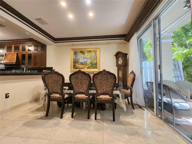 a dining hall with stainless steel appliances granite countertop a sink a refrigerator and a microwave