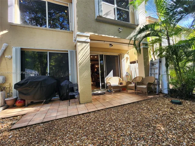 a view of a yard with chairs in a patio