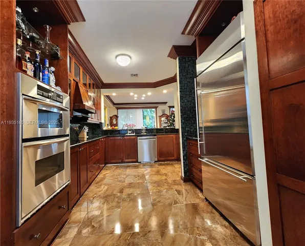 a kitchen with stainless steel appliances granite countertop a refrigerator and a sink