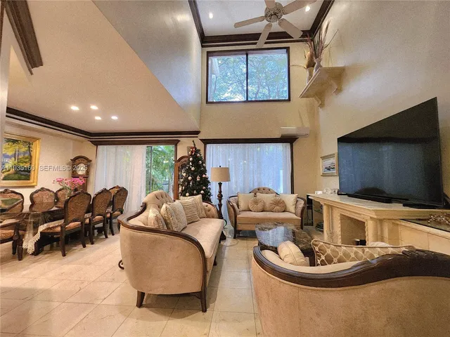 a living room with furniture a flat screen tv and kitchen view