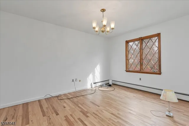 a view of empty room with wooden floor and windows