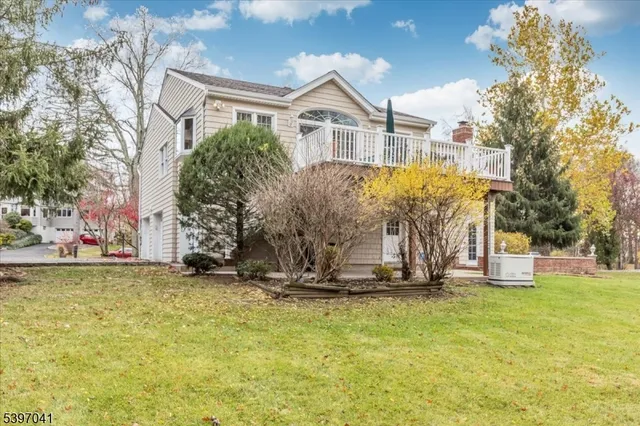 a view of a house with a big yard plants and large trees