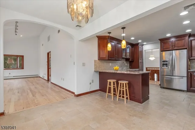 a kitchen with stainless steel appliances granite countertop wooden cabinets a stove a sink and a refrigerator