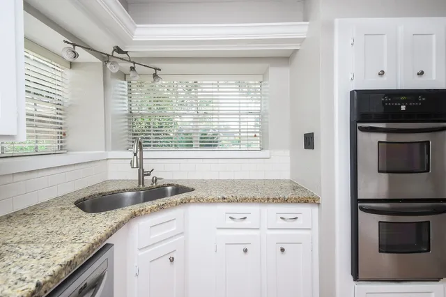 a kitchen with granite countertop a sink and a stove