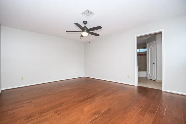 a view of an empty room with wooden floor