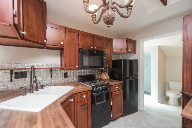 a kitchen with stainless steel appliances granite countertop a sink a stove and a refrigerator