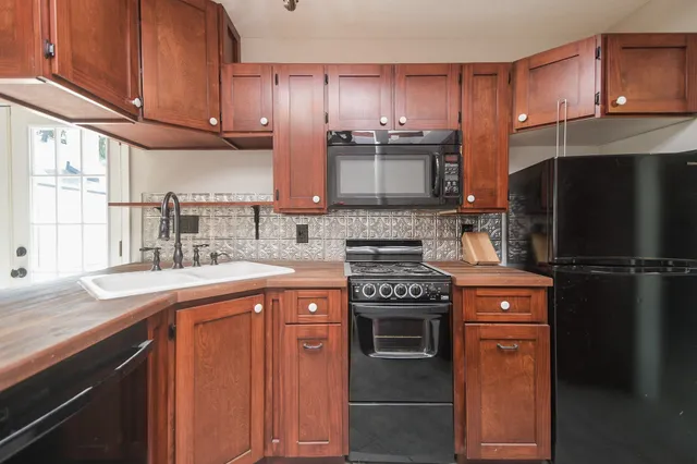 a kitchen with stainless steel appliances granite countertop a refrigerator stove and sink