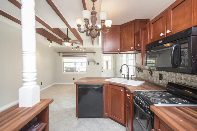 a kitchen with stainless steel appliances granite countertop a sink a stove and a wooden floors