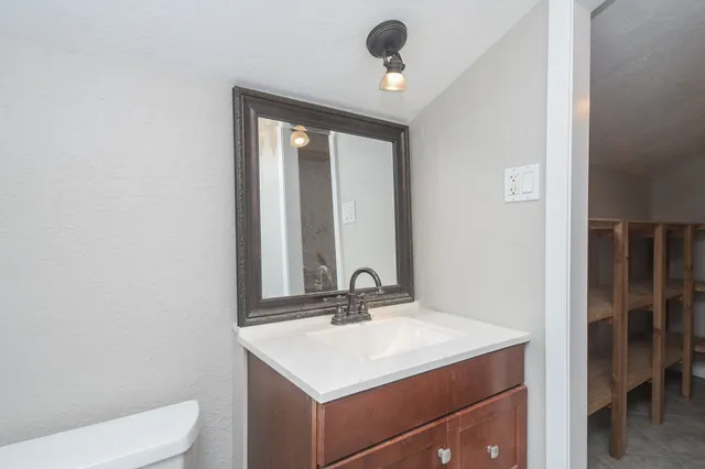 a bathroom with a toilet sink and mirror