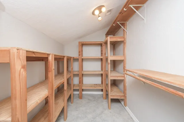 a view of walk in closet with empty racks