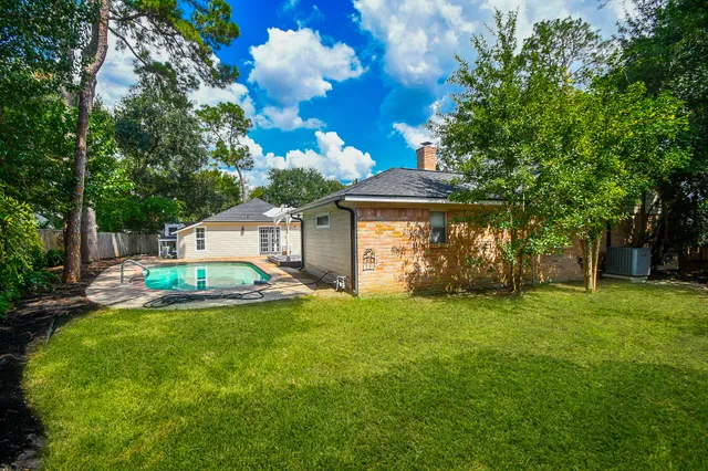 a view of a house with backyard and sitting area
