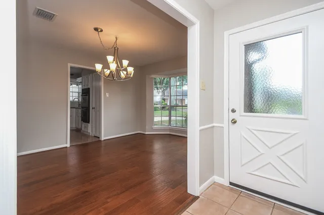 a view of a livingroom with wooden floor and a large window