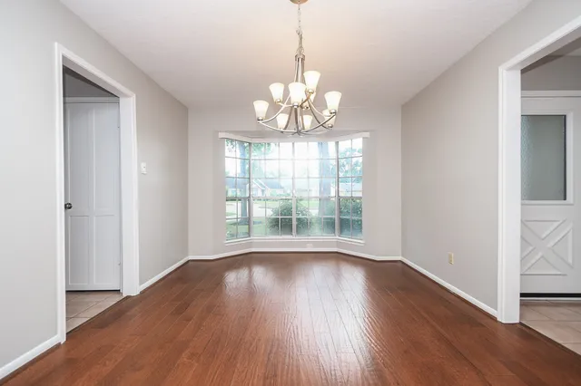 a view of a room with wooden floor and chandelier