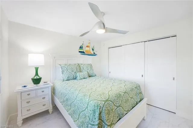a bedroom with a bed dresser and a lamp on table
