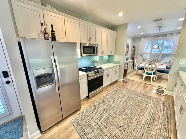 a kitchen with granite countertop a stove sink and refrigerator
