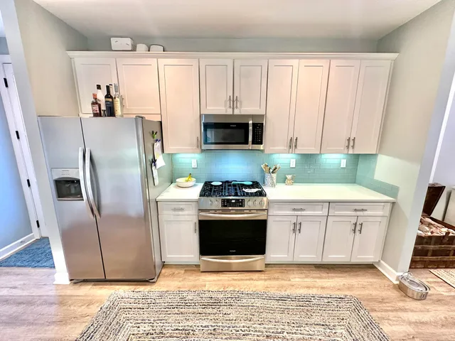 a bedroom with a bed a couch and a flat tv screen on the dresser