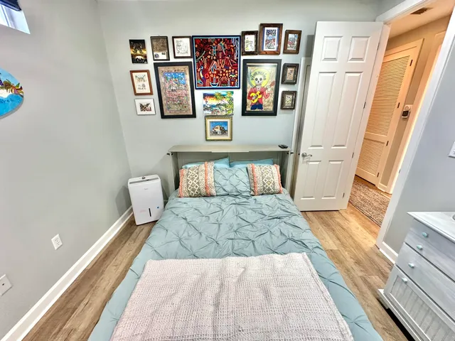 a spacious bedroom with a bed a couch and a dresser next to a window