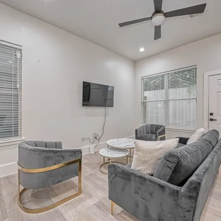 a living room with furniture and a view of kitchen