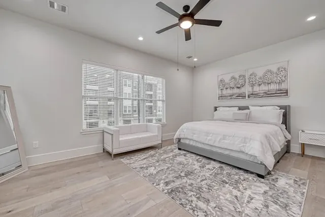 a bedroom with a large bed and a ceiling fan