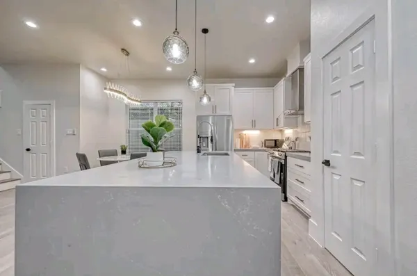 a kitchen with stainless steel appliances granite countertop a sink a stove and a refrigerator