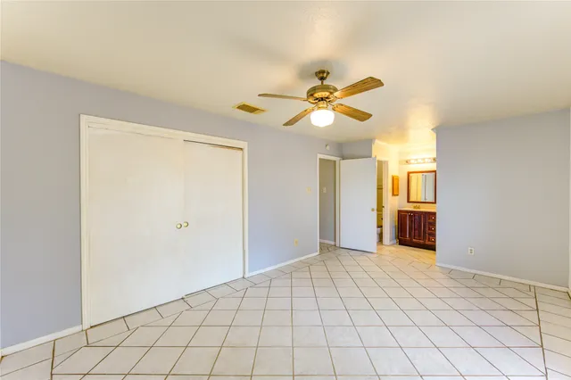 a view of an empty room and chandelier fan