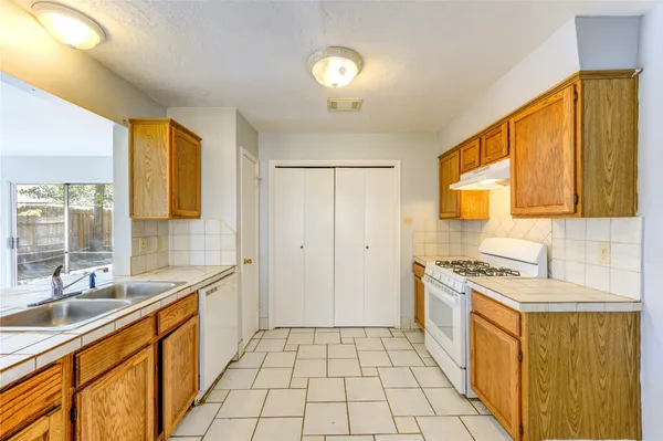 a kitchen with a sink stove and cabinets