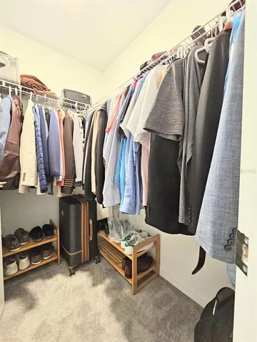 a view of walk in closet with clothes and shoes