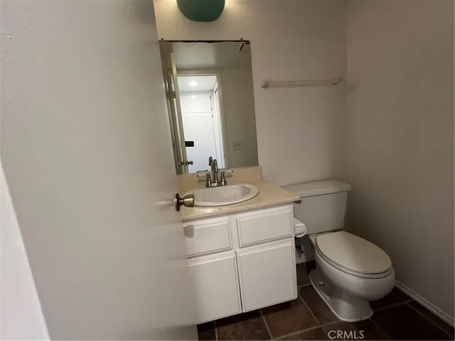 a bathroom with a toilet a sink and mirror