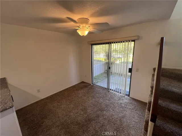 a view of a livingroom with a ceiling fan and window