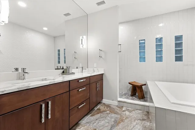 a bathroom with a tub sink shower and mirror