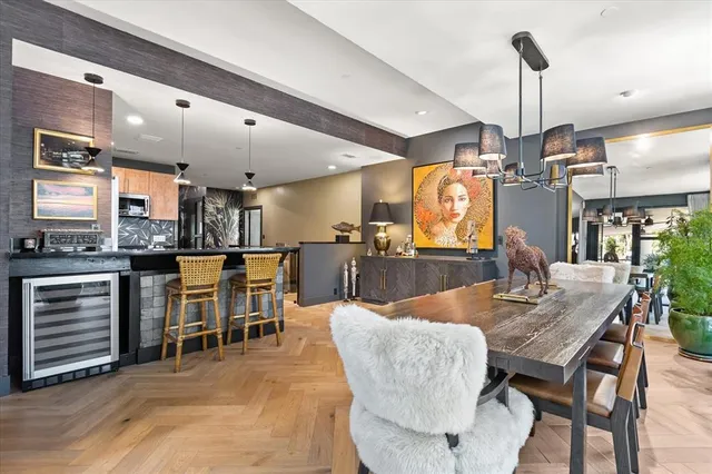 a dining room with furniture a chandelier and wooden floor