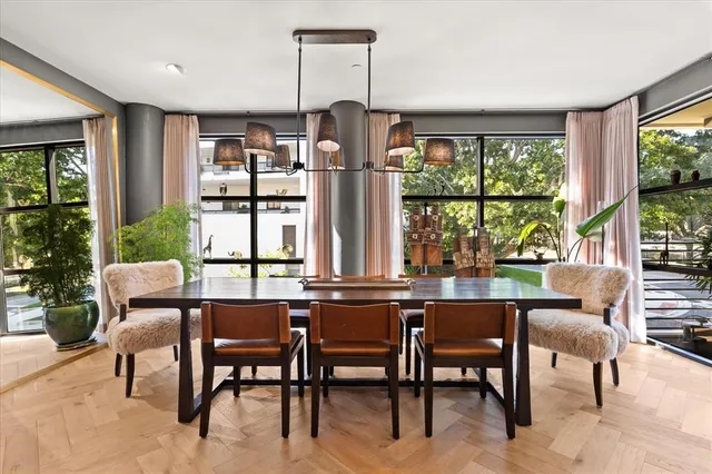 a dining room with furniture a chandelier and wooden floor