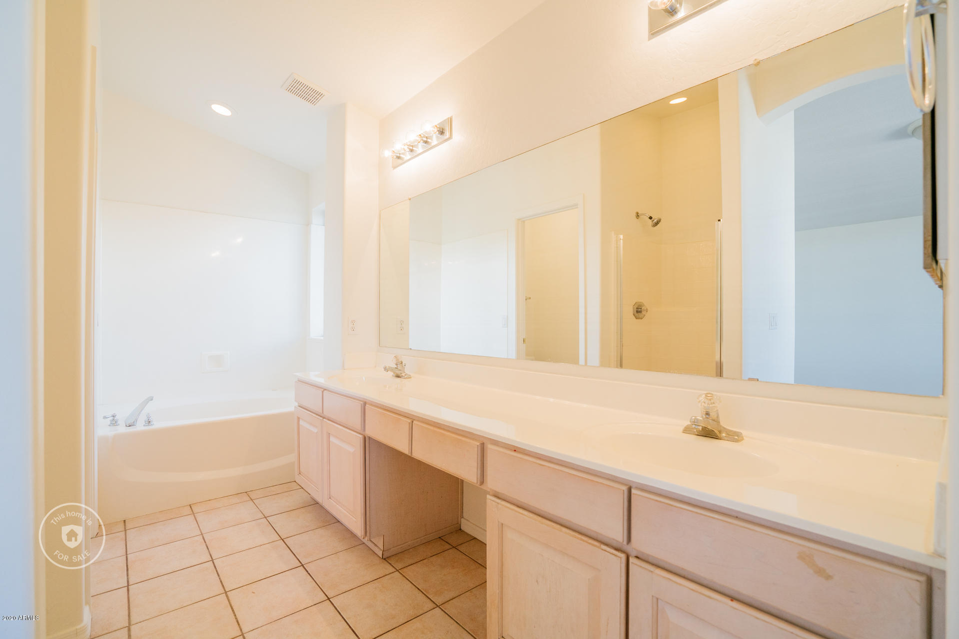 11245 West Almeria Road Avondale, AZ 85392 - Photo 19 of 23 a spacious bathroom with a bathtub sink and mirror