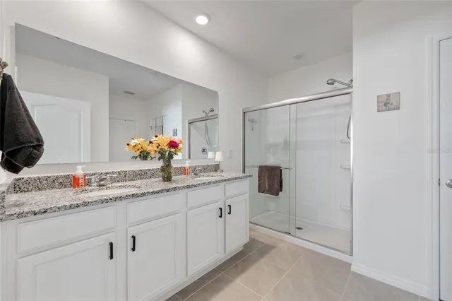 a bathroom with a double vanity sink mirror and shower