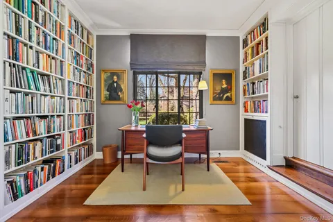 a living room with furniture a bookshelf and a window