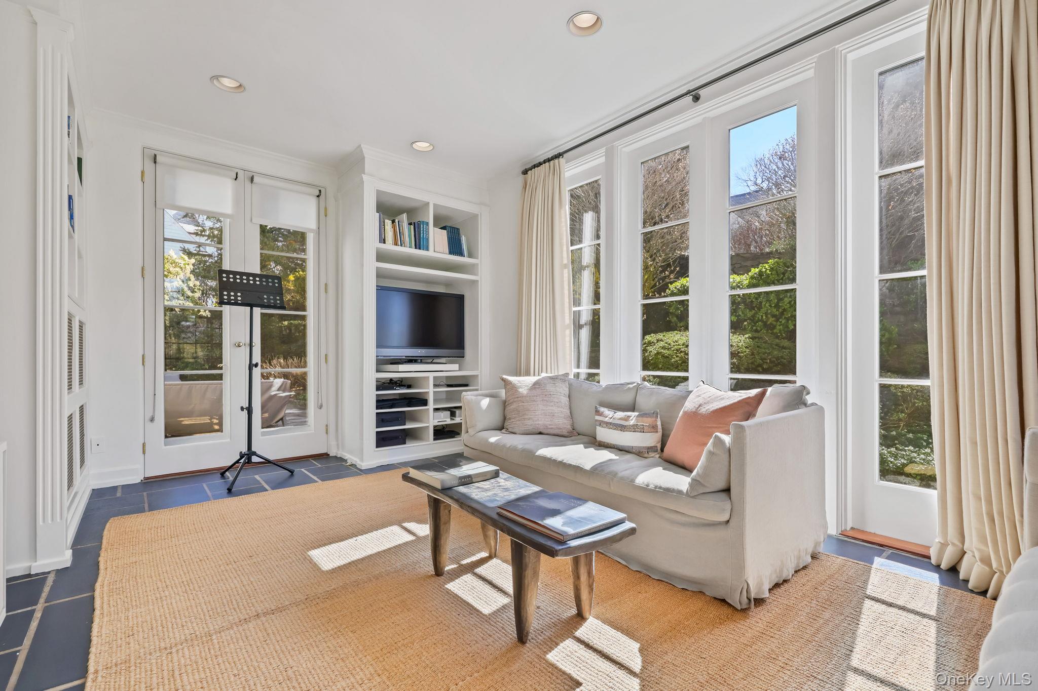4 High Road Bronxville, NY 10708 - Photo 8 of 32 a living room with furniture a flat screen tv and a large window