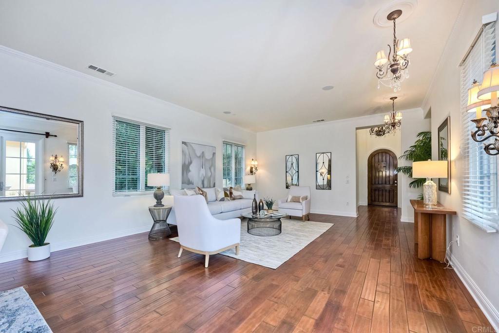 17284 Reflections Circle San Diego, CA 92127 - Photo 30 of 53 a living room with furniture a chandelier and wooden floor