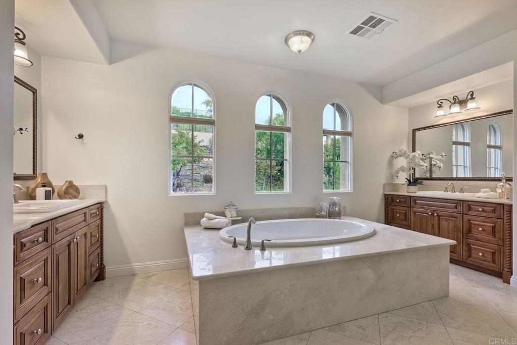 17284 Reflections Circle San Diego, CA 92127 - Photo 36 of 53 a spacious bathroom with a granite countertop tub a double vanity sink a window and a mirror